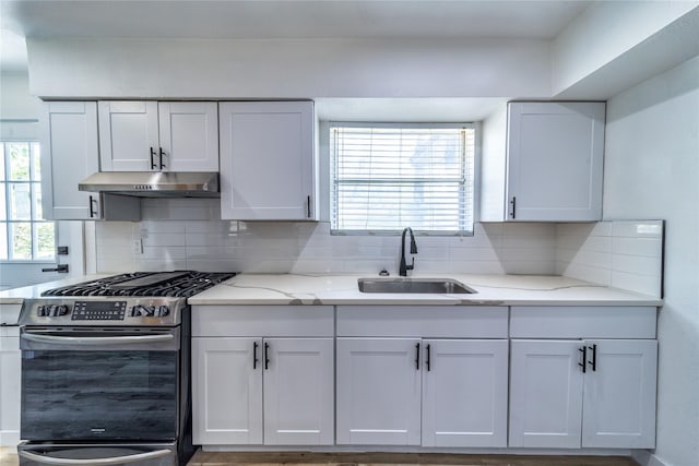 3452 Antilles Dr, Mesquite, TX 75150 - kitchen with stainless steel gas range oven, a sink, under cabinet range hood, backsplash, and light stone counters