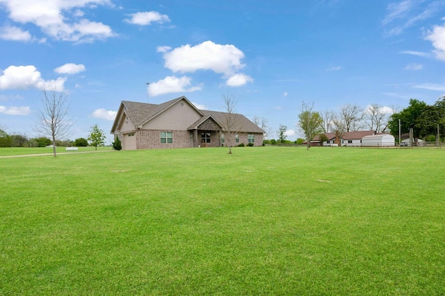 view of front of home featuring brick siding, a front lawn, and roof with shingles