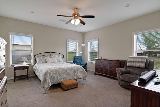 bedroom with baseboards, visible vents, and light colored carpet
