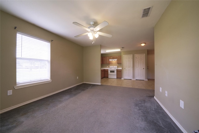 unfurnished living room with light carpet, visible vents, baseboards, and ceiling fan