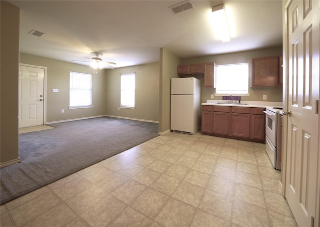 kitchen featuring a sink, visible vents, light countertops, and white appliances