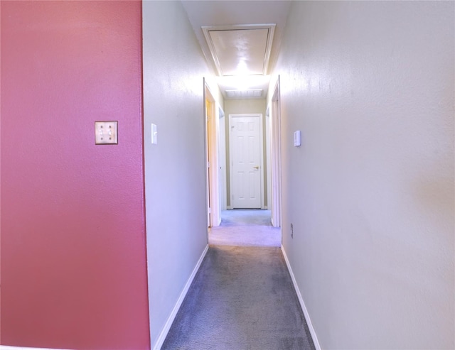 corridor with attic access, baseboards, and carpet floors