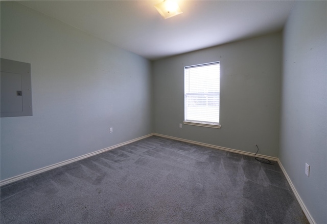 carpeted spare room featuring baseboards and electric panel