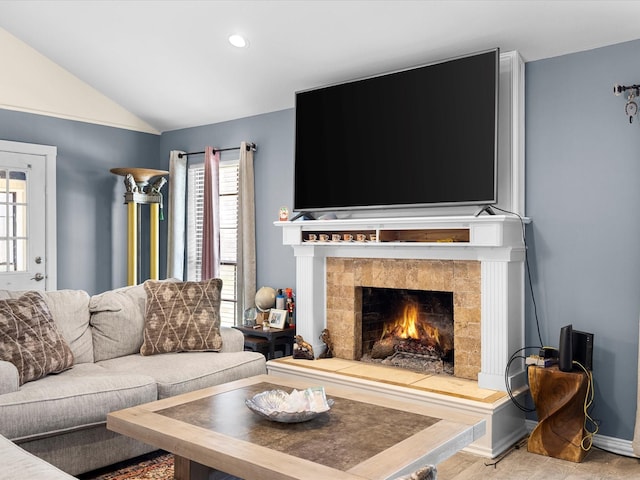 living room featuring a tile fireplace, baseboards, recessed lighting, and vaulted ceiling