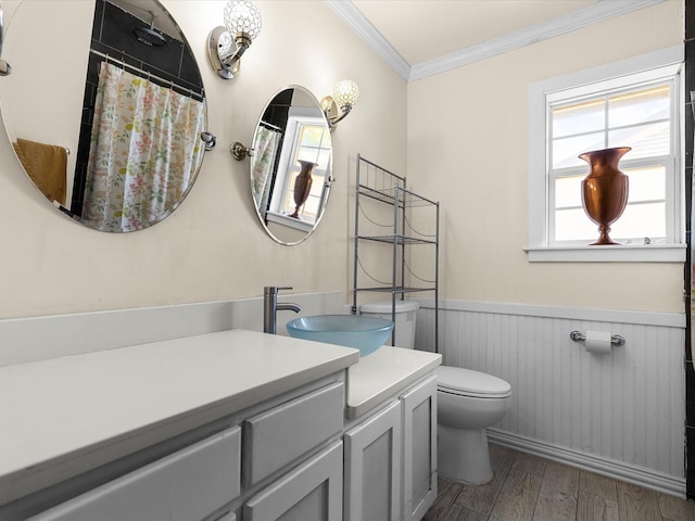 bathroom featuring a wainscoted wall, wood finished floors, a wealth of natural light, and ornamental molding