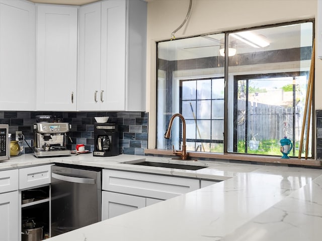 kitchen with white cabinets, tasteful backsplash, appliances with stainless steel finishes, and a sink