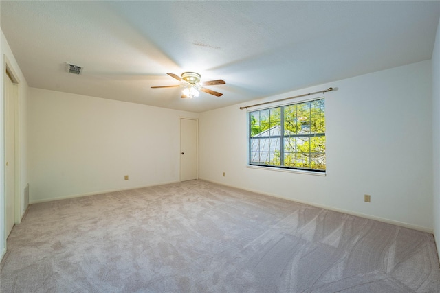empty room featuring baseboards, light colored carpet, ceiling fan, and visible vents