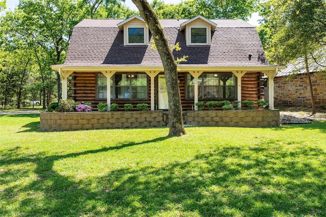 view of front of home with roof with shingles, a front lawn, and log exterior