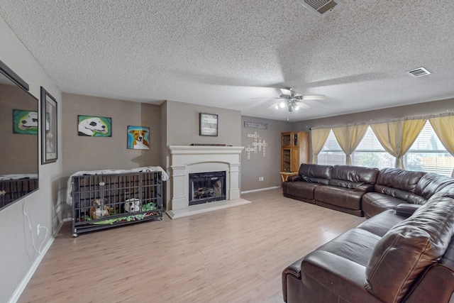 8202 Silverton Dr, Arlington, TX 76001 - living room with ceiling fan, a fireplace with raised hearth, visible vents, wood finished floors, and baseboards