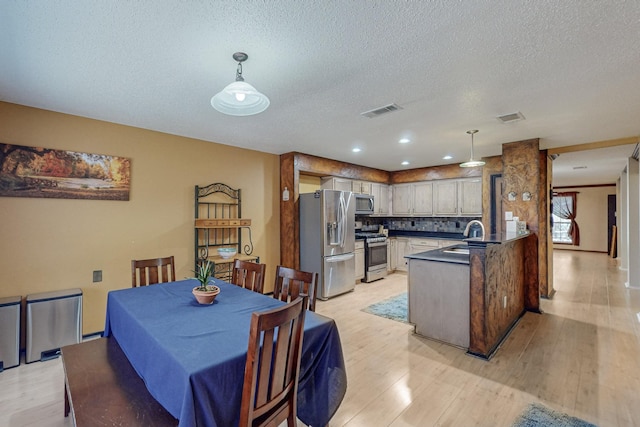 8202 Silverton Dr, Arlington, TX 76001 - dining space with light wood finished floors, visible vents, and a textured ceiling