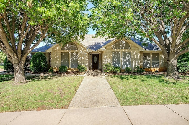 view of front of home with brick siding and a front yard