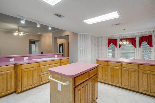 kitchen with light countertops, a kitchen island, visible vents, and light tile patterned floors