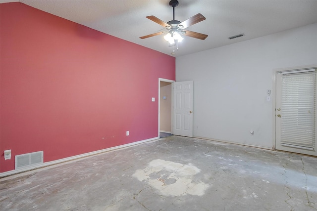 unfurnished room with concrete flooring, a ceiling fan, visible vents, and baseboards