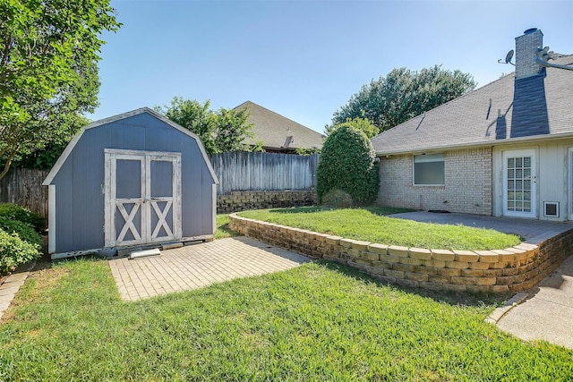 view of yard with an outdoor structure, fence, a patio, and a shed