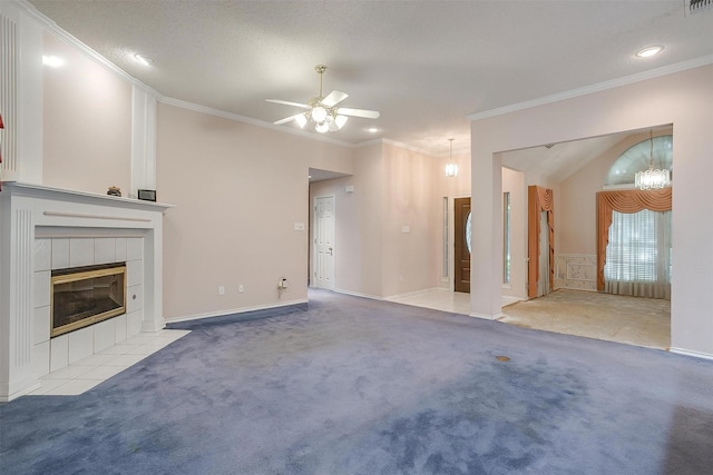 unfurnished living room featuring carpet floors, a ceiling fan, crown molding, and a tiled fireplace