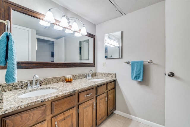 1028 Signal Ridge Pl, Rockwall, TX 75032 - bathroom with tile patterned floors, double vanity, baseboards, and a sink