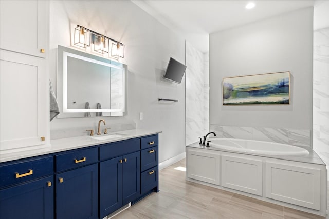 full bath with baseboards, recessed lighting, a bath, and vanity