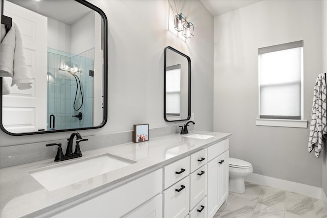 bathroom featuring marble finish floor, a sink, a shower stall, and baseboards