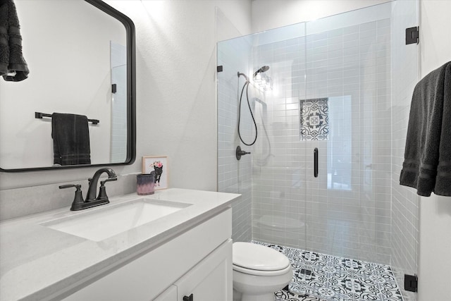 bathroom with tile patterned floors, vanity, toilet, and a shower stall