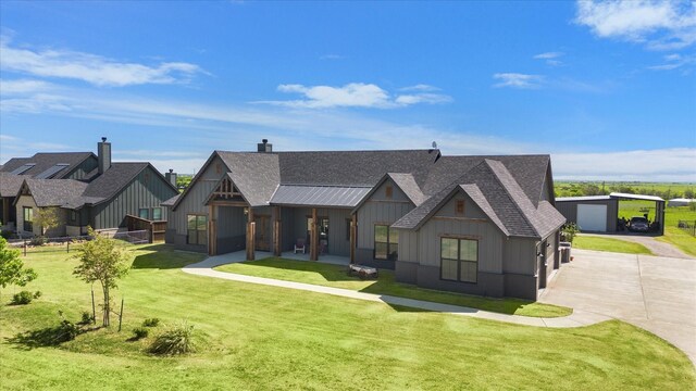 view of front of house featuring a front lawn, board and batten siding, a shingled roof, and driveway
