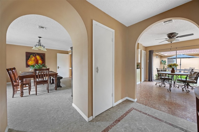 1803 Michael Ct, Arlington, TX 76010 - hall featuring arched walkways, a textured ceiling, baseboards, tile patterned flooring, and a chandelier