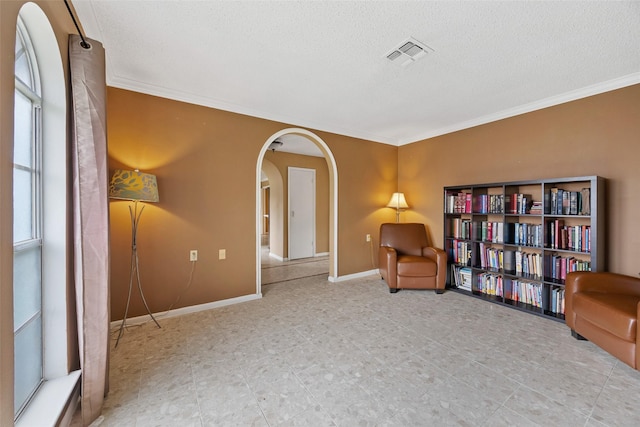 1803 Michael Ct, Arlington, TX 76010 - sitting room featuring a textured ceiling, arched walkways, crown molding, and baseboards