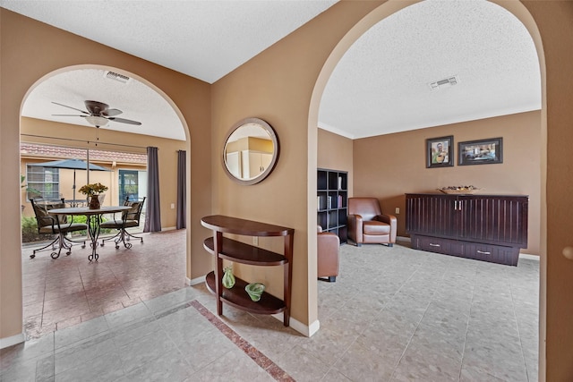 1803 Michael Ct, Arlington, TX 76010 - hallway with a textured ceiling, arched walkways, baseboards, and tile patterned floors