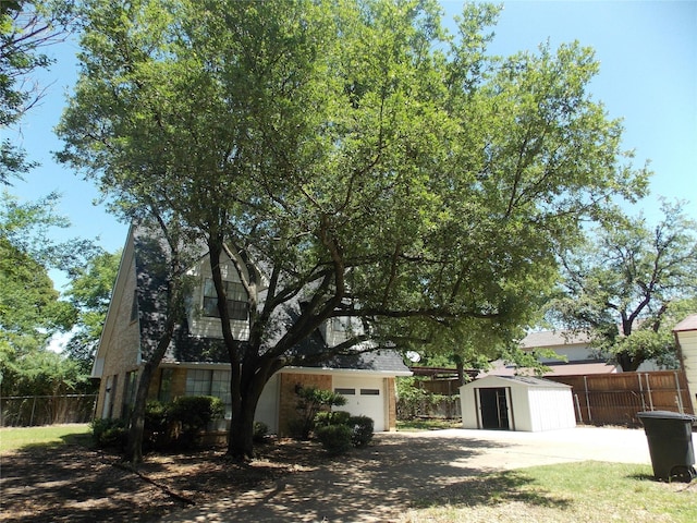 exterior space with fence, an outdoor structure, and a shed