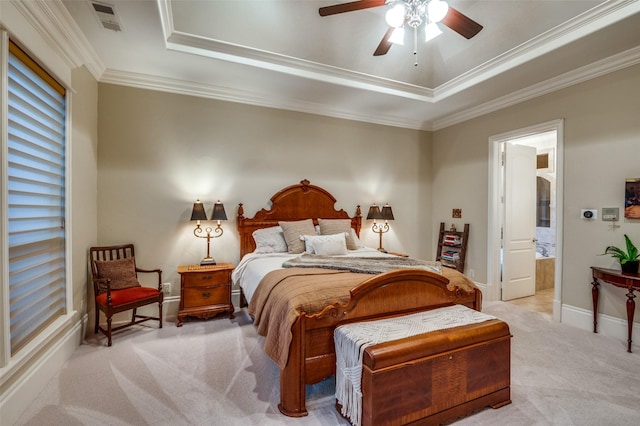 bedroom featuring a tray ceiling, light colored carpet, ornamental molding, baseboards, and ensuite bathroom