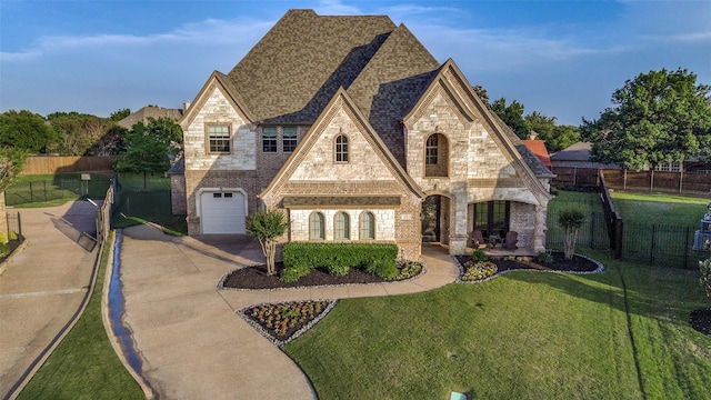french country home with stone siding, concrete driveway, a garage, and brick siding