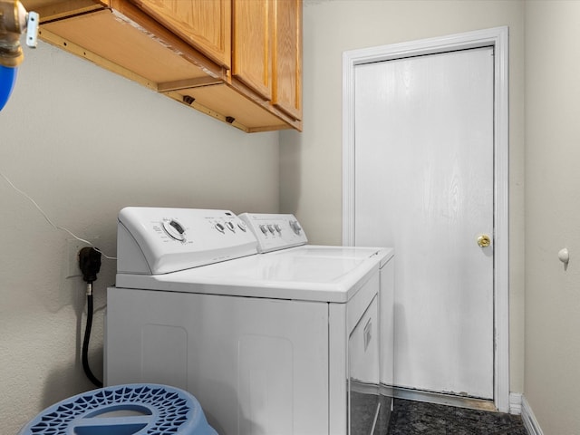 laundry area with washing machine and clothes dryer, baseboards, and cabinet space