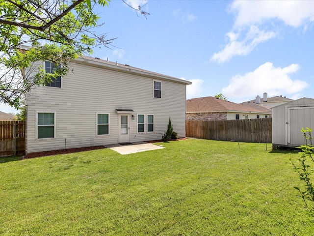 rear view of property with a shed, a patio area, a fenced backyard, an outbuilding, and a lawn