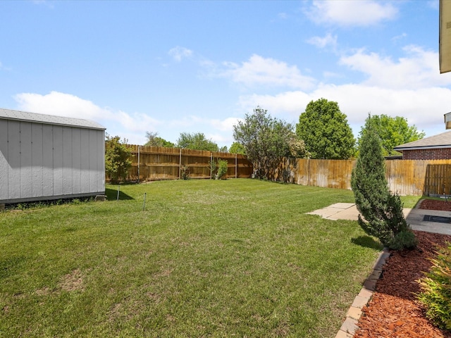 view of yard with an outbuilding, a fenced backyard, and a shed