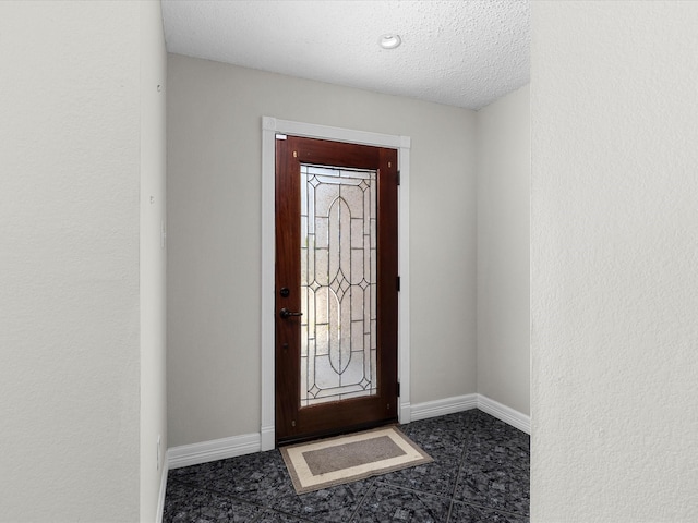 entryway with baseboards and a textured ceiling