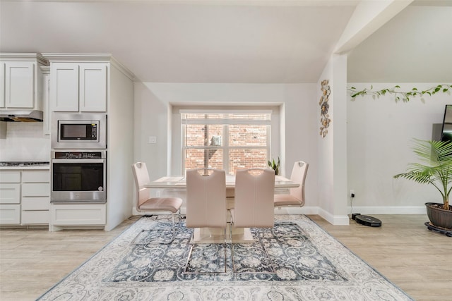 dining space with light wood-style flooring and baseboards