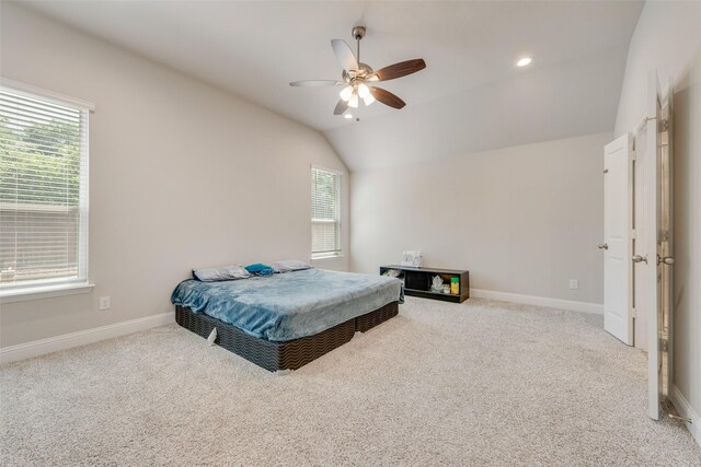 bedroom featuring vaulted ceiling, carpet flooring, baseboards, and multiple windows