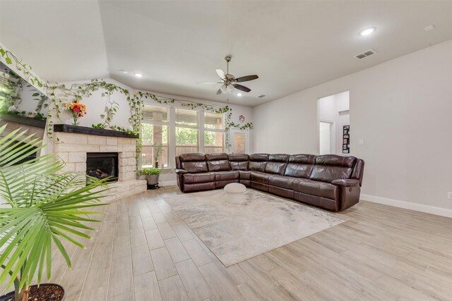 living room with baseboards, wood finished floors, visible vents, and ceiling fan