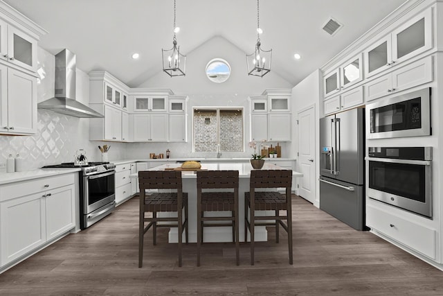 3616 Hickory St, Sherman, TX 75092 - kitchen featuring appliances with stainless steel finishes, wall chimney exhaust hood, a kitchen breakfast bar, light countertops, and a kitchen island