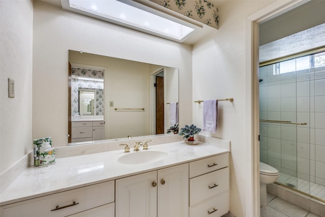 full bath featuring a stall shower, toilet, tile patterned floors, vanity, and a skylight