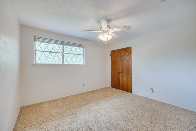 carpeted empty room featuring ceiling fan
