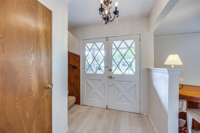 entryway with stairs, an inviting chandelier, wood finished floors, and baseboards