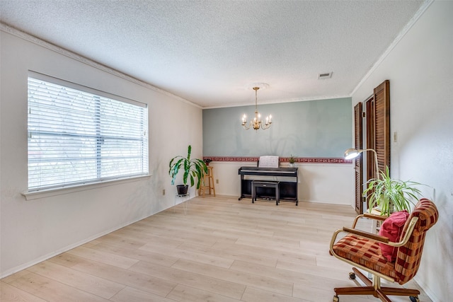 sitting room with visible vents, wood finished floors, an inviting chandelier, and a textured ceiling