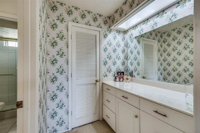 full bathroom featuring vanity, a closet, toilet, a stall shower, and wallpapered walls