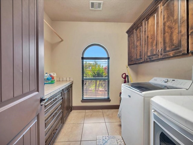 194 Royal Pnes, Lufkin, TX 75904 - laundry room featuring separate washer and dryer, cabinet space, light tile patterned floors, a textured ceiling, and baseboards