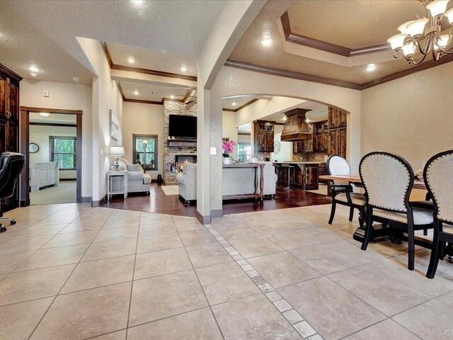 194 Royal Pnes, Lufkin, TX 75904 - foyer with ornamental molding, a tray ceiling, light tile patterned flooring, a chandelier, and arched walkways