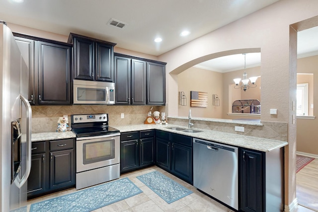 6948 Carrington Ln, Fort Worth, TX 76137 - kitchen with arched walkways, a sink, light stone countertops, and stainless steel appliances