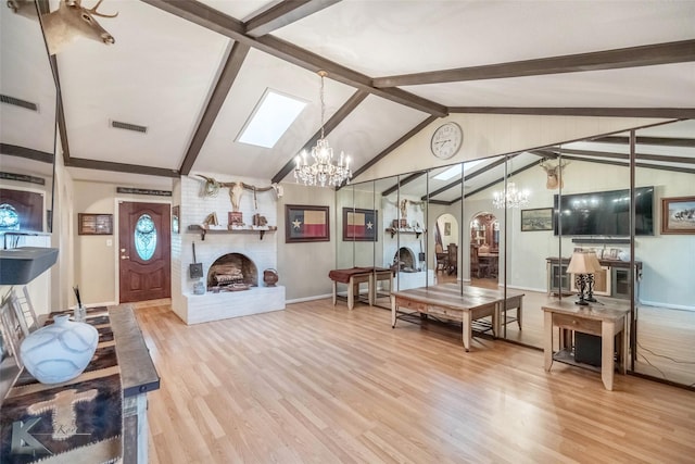 living room with a notable chandelier, visible vents, a brick fireplace, vaulted ceiling with beams, and wood finished floors