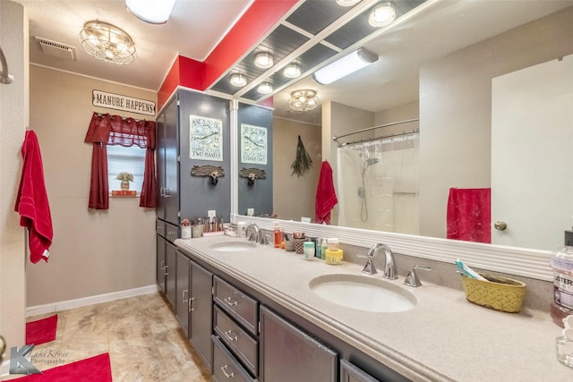 bathroom featuring a sink, visible vents, baseboards, and double vanity