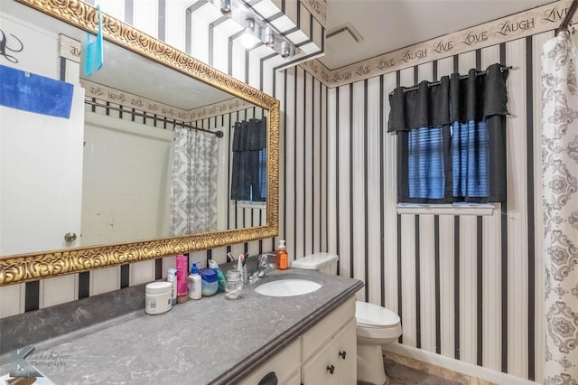 bathroom featuring toilet, wallpapered walls, vanity, and visible vents