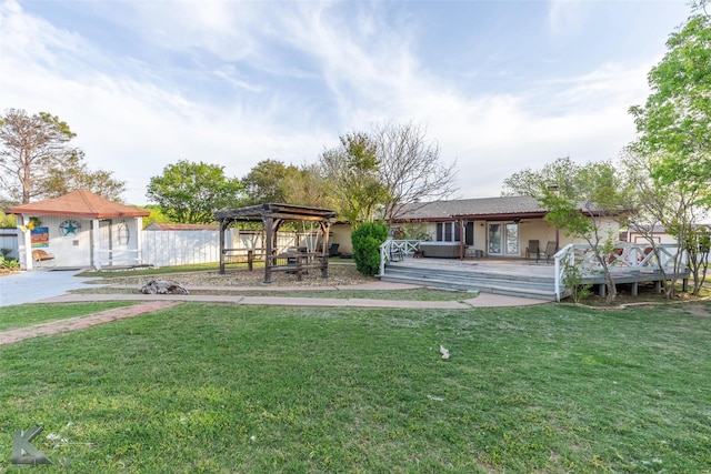 view of yard featuring a deck, a pergola, and fence